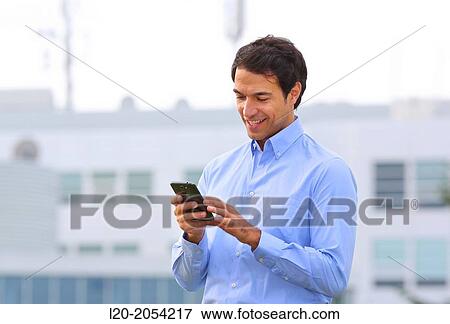 Stock Photo - Businessman with smartphone business center. San Sebastian Technology Park. Donostia. Gipuzkoa. Basque Country. Spain.. Fotosearch