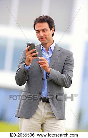 Businessman with smartphone business center. San Sebastian Technology Park. Donostia. Gipuzkoa. Basque Country. Spain. View Large Photo Image Stock Photograph - Businessman with smartphone business center. San Sebastian Technology Park. Donostia. Gipuzkoa. Basque Country. Spain.. Fotosearch