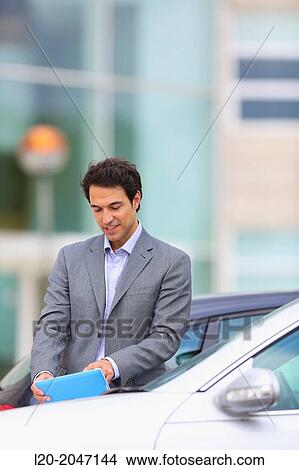 Businessman with tablet in parking business center. San Sebastian Technology Park. Donostia. Gipuzkoa. Basque Country. Spain. View Large Photo Image Picture - Businessman with tablet in parking business center. San Sebastian Technology Park. Donostia. Gipuzkoa. Basque Country. Spain.. Fotosearch