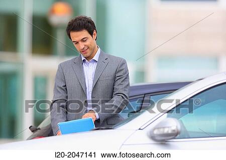Businessman with tablet in parking business center. San Sebastian Technology Park. Donostia. Gipuzkoa. Basque Country. Spain. View Large Photo Image Stock Image - Businessman with tablet in parking business center. San Sebastian Technology Park. Donostia. Gipuzkoa. Basque Country. Spain.. Fotosearch