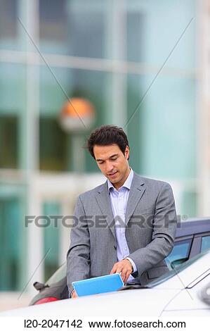 Businessman with tablet in parking business center. San Sebastian Technology Park. Donostia. Gipuzkoa. Basque Country. Spain. View Large Photo Image Stock Image - Businessman with tablet in parking business center. San Sebastian Technology Park. Donostia. Gipuzkoa. Basque Country. Spain.. Fotosearch