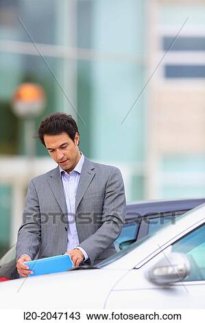 Businessman with tablet in parking business center. San Sebastian Technology Park. Donostia. Gipuzkoa. Basque Country. Spain. View Large Photo Image Stock Image - Businessman with tablet in parking business center. San Sebastian Technology Park. Donostia. Gipuzkoa. Basque Country. Spain.. Fotosearch