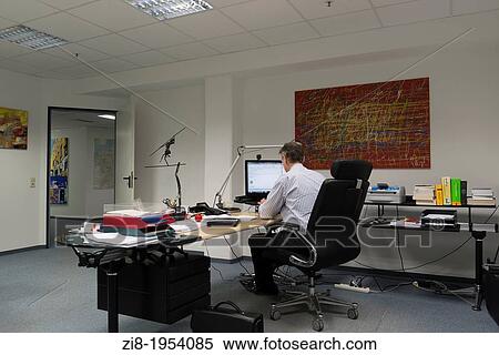 Stock Photography - Businessman working late in the office. Fotosearch