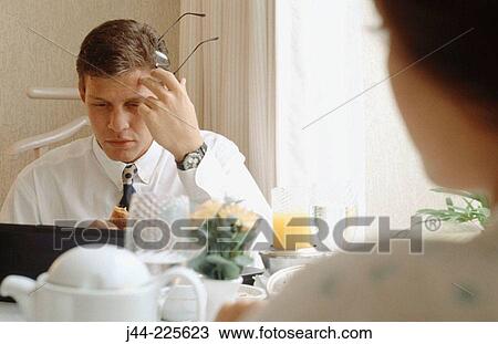 Businessman working with laptop computer while having breakfast at home View Large Photo Image Stock Image - Businessman working with laptop computer while having breakfast at home. Fotosearch