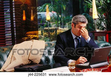 Businessman working with laptop computer in a hotel lounge View Large Photo Image Stock Image - Businessman working with laptop computer in a hotel lounge. Fotosearch