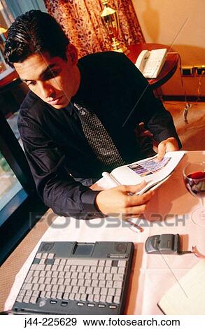 Businessman working with laptop computer on a table in a hotel room View Large Photo Image Stock Photo - Businessman working with laptop computer on a table in a hotel room. Fotosearch