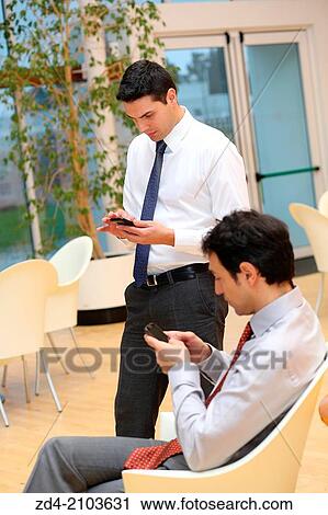 Stock Image - Businessmen using smartphones. Fotosearch