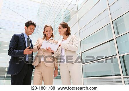 Stock Photo - Businesspeople using digital tablet. Fotosearch