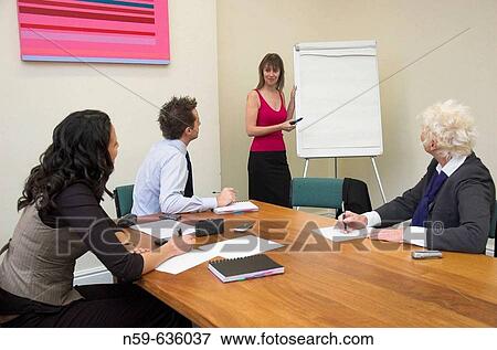 Businesswoman about to start a presentation using a flip chart at a small business meeting. View Large Photo Image Stock Photo - Businesswoman about to start a presentation using a flip chart at a small business meeting.. Fotosearch