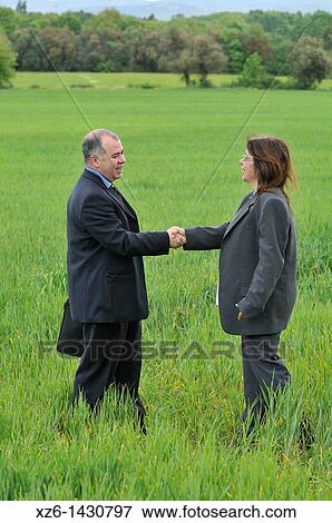 businesswoman and businessman shaking hands in green nature View Large Photo Image Stock Photo - businesswoman and businessman shaking hands in green nature. Fotosearch