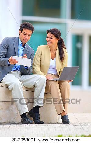 Businesswoman and businessman sitting on business center. San Sebastian Technology Park. Donostia. Gipuzkoa. Basque Country. Spain View Large Photo Image Stock Image - Businesswoman and businessman sitting on business center. San Sebastian Technology Park. Donostia. Gipuzkoa. Basque Country. Spain. Fotosearch