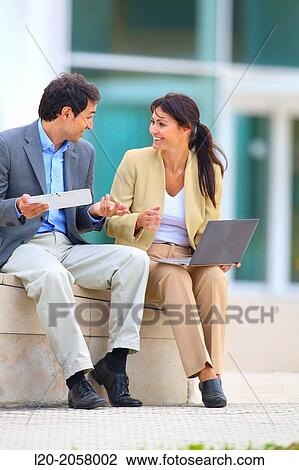 Stock Image - Businesswoman and businessman sitting on business center. San Sebastian Technology Park. Donostia. Gipuzkoa. Basque Country. Spain. Fotosearch