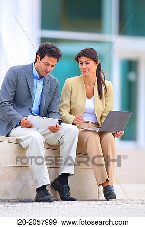 Businesswoman and businessman sitting on business center. San Sebastian Technology Park. Donostia. Gipuzkoa. Basque Country. Spain View Large Photo Image Stock Photo - Businesswoman and businessman sitting on business center. San Sebastian Technology Park. Donostia. Gipuzkoa. Basque Country. Spain. Fotosearch