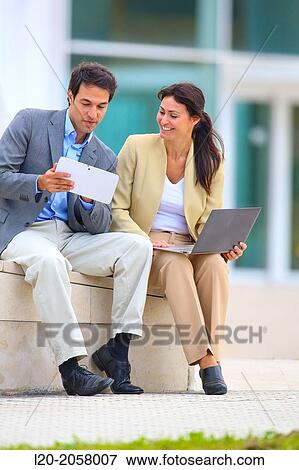 Businesswoman and businessman sitting on business center. San Sebastian Technology Park. Donostia. Gipuzkoa. Basque Country. Spain View Large Photo Image Stock Photo - Businesswoman and businessman sitting on business center. San Sebastian Technology Park. Donostia. Gipuzkoa. Basque Country. Spain. Fotosearch