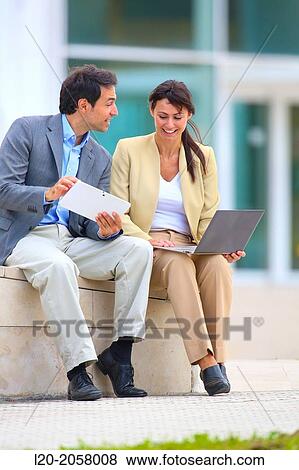 Businesswoman and businessman sitting on business center. San Sebastian Technology Park. Donostia. Gipuzkoa. Basque Country. Spain View Large Photo Image Stock Photo - Businesswoman and businessman sitting on business center. San Sebastian Technology Park. Donostia. Gipuzkoa. Basque Country. Spain. Fotosearch
