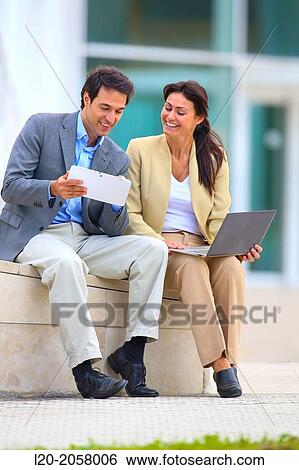 Stock Photograph - Businesswoman and businessman sitting on business center. San Sebastian Technology Park. Donostia. Gipuzkoa. Basque Country. Spain. Fotosearch