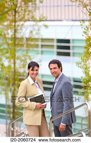 Picture - Businesswoman and businessman talking on stairs. business center. San Sebastian Technology Park. Donostia. Gipuzkoa. Basque Country. Spain.. Fotosearch