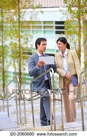 Stock Image - Businesswoman and businessman talking on stairs. business center. San Sebastian Technology Park. Donostia. Gipuzkoa. Basque Country. Spain.. Fotosearch