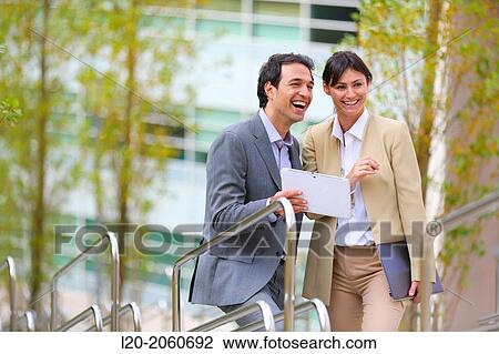 Stock Image - Businesswoman and businessman talking on stairs. business center. San Sebastian Technology Park. Donostia. Gipuzkoa. Basque Country. Spain.. Fotosearch