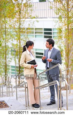 Stock Image - Businesswoman and businessman talking on stairs. business center. San Sebastian Technology Park. Donostia. Gipuzkoa. Basque Country. Spain.. Fotosearch