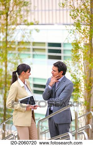 Stock Image - Businesswoman and businessman talking on stairs. business center. San Sebastian Technology Park. Donostia. Gipuzkoa. Basque Country. Spain.. Fotosearch