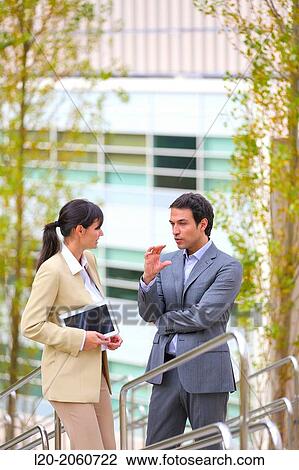 Stock Image - Businesswoman and businessman talking on stairs. business center. San Sebastian Technology Park. Donostia. Gipuzkoa. Basque Country. Spain.. Fotosearch