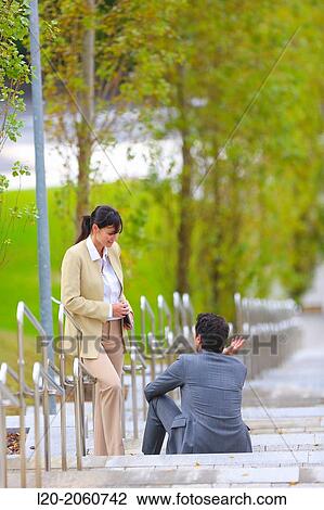 Stock Image - Businesswoman and businessman talking on stairs. business center. San Sebastian Technology Park. Donostia. Gipuzkoa. Basque Country. Spain.. Fotosearch