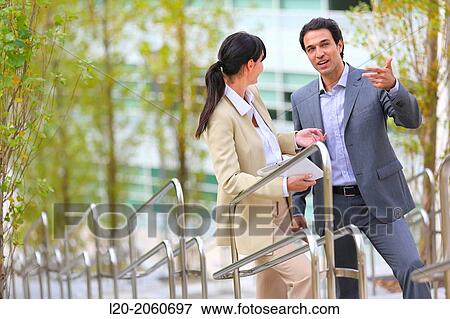 Stock Photo - Businesswoman and businessman talking on stairs. business center. San Sebastian Technology Park. Donostia. Gipuzkoa. Basque Country. Spain.. Fotosearch