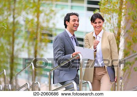 Stock Photograph - Businesswoman and businessman talking on stairs. business center. San Sebastian Technology Park. Donostia. Gipuzkoa. Basque Country. Spain.. Fotosearch