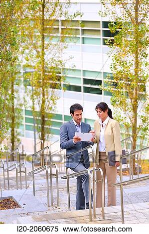 Stock Photography - Businesswoman and businessman talking on stairs. business center. San Sebastian Technology Park. Donostia. Gipuzkoa. Basque Country. Spain.. Fotosearch