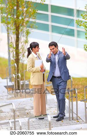 Stock Photography - Businesswoman and businessman talking on stairs. business center. San Sebastian Technology Park. Donostia. Gipuzkoa. Basque Country. Spain.. Fotosearch