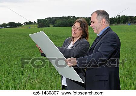businesswoman and businessman with blueprints in the field View Large Photo Image Stock Photo - businesswoman and businessman with blueprints in the field. Fotosearch