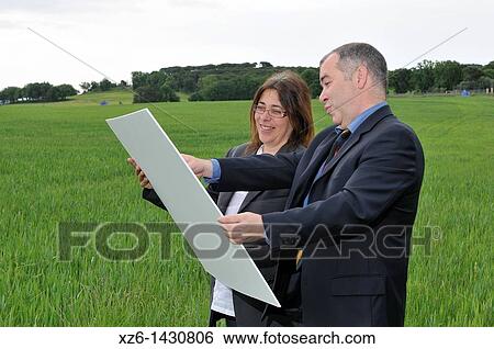 businesswoman and businessman with blueprints in the field View Large Photo Image Stock Photograph - businesswoman and businessman with blueprints in the field. Fotosearch