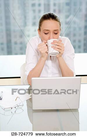 businesswoman by laptop holding cup, portrait View Large Photo Image Stock Photo - businesswoman by laptop holding cup, portrait. Fotosearch
