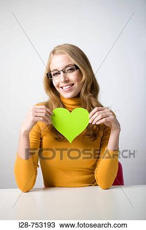 Stock Image - Businesswoman holding cut-out heart. Fotosearch