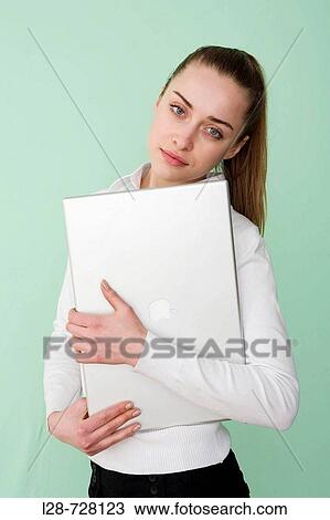 Stock Image - Businesswoman holding laptop portrait. Fotosearch