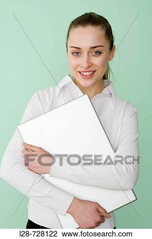 Businesswoman holding laptop, smiling, portrait View Large Photo Image Stock Image - Businesswoman holding laptop, smiling, portrait. Fotosearch