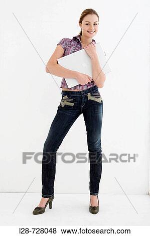 Stock Photo - Businesswoman holding laptop, smiling, portrait. Fotosearch