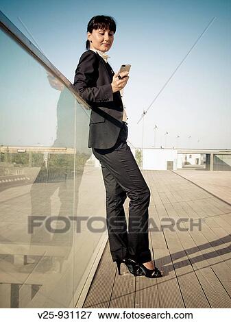 Stock Photo - Businesswoman looking at cell phone. Fotosearch