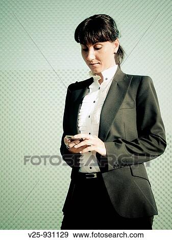 Businesswoman looking at cell phone View Large Photo Image Stock Photo - Businesswoman looking at cell phone. Fotosearch