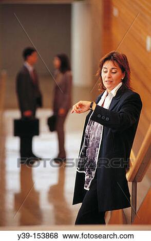 Businesswoman looking at her watch View Large Photo Image Stock Photo - Businesswoman looking at her watch. Fotosearch