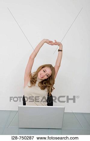 Businesswoman stretching at desk View Large Photo Image Stock Photo - Businesswoman stretching at desk. Fotosearch