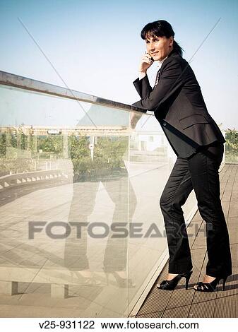 Stock Image - Businesswoman talking on cell phone. Fotosearch