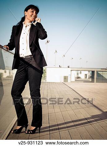 Stock Image - Businesswoman talking on cell phone. Fotosearch