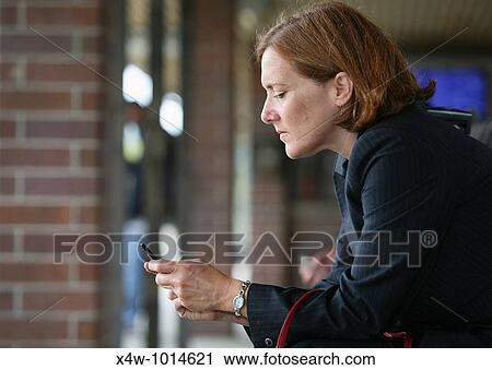 Businesswoman texting while waiting for train View Large Photo Image Stock Image - Businesswoman texting while waiting for train. Fotosearch
