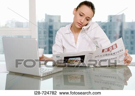 Businesswoman using telephone and laptop in office View Large Photo Image Stock Image - Businesswoman using telephone and laptop in office. Fotosearch
