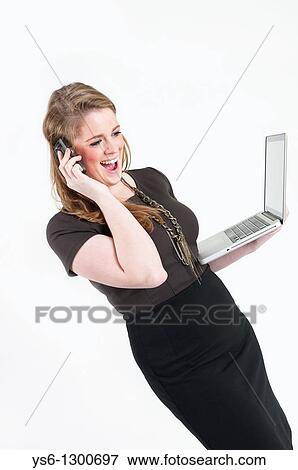 Businesswoman with cell phone and laptop smiling and talking View Large Photo Image Stock Photo - Businesswoman with cell phone and laptop smiling and talking. Fotosearch