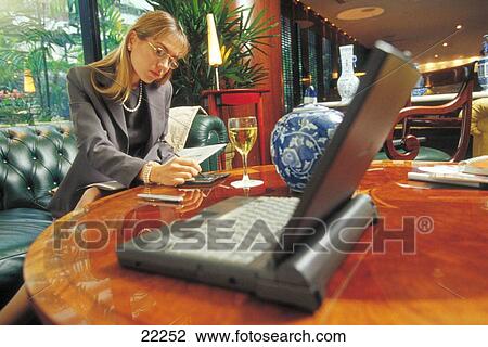 Businesswoman working in a hotel lounge View Large Photo Image Stock Image - Businesswoman working in a hotel lounge. Fotosearch