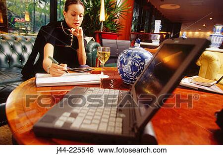 Businesswoman working in a hotel lounge View Large Photo Image Stock Photograph - Businesswoman working in a hotel lounge. Fotosearch