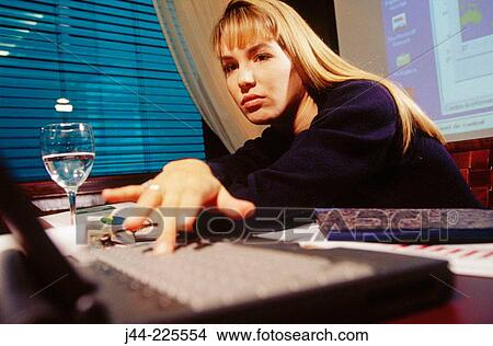 Businesswoman working on a desk with laptop computer in an office View Large Photo Image Picture - Businesswoman working on a desk with laptop computer in an office. Fotosearch